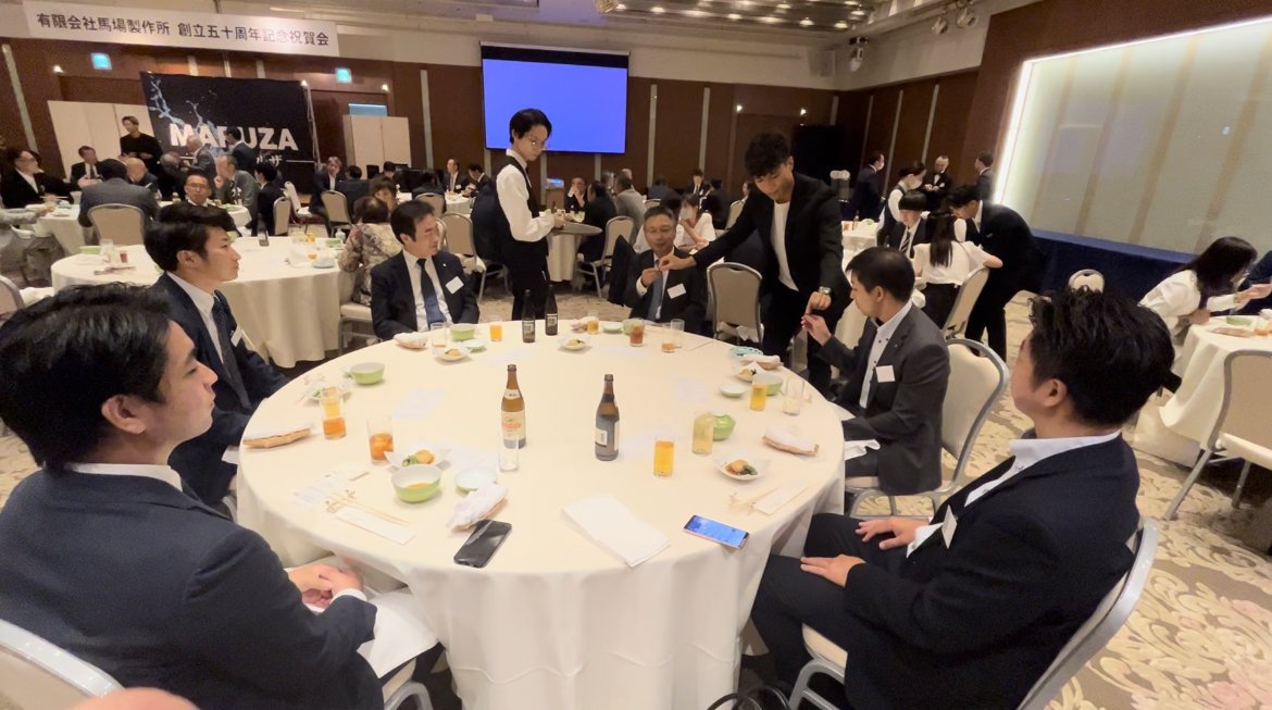 宴会会場のテーブルでマジックを披露するMARUZA