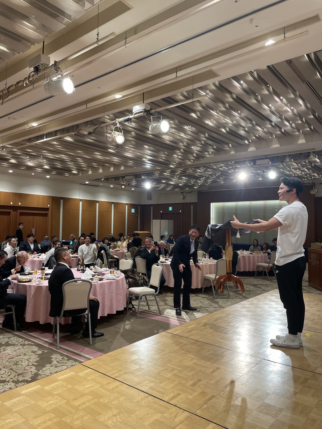 宴会会場のステージでマジックを披露するMARUZA